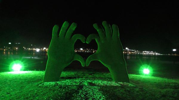 Зеленые руки, сложенные в сердечко ночью - Новороссийск район Мыса любви