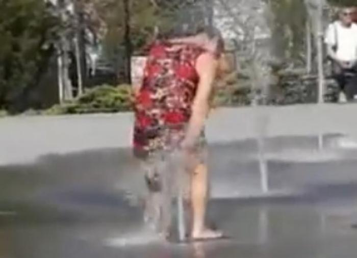 Голая девушка купается в фонтане